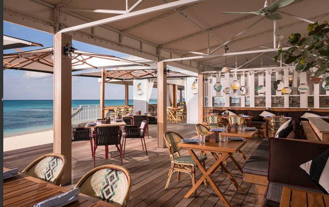 sunny beach cafe with rattan seats and wood tables